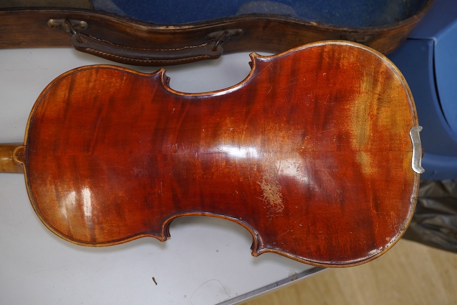 A late 19th century violin, bears fake Stradivarius label, cased, back measures 36cm. Condition - fair